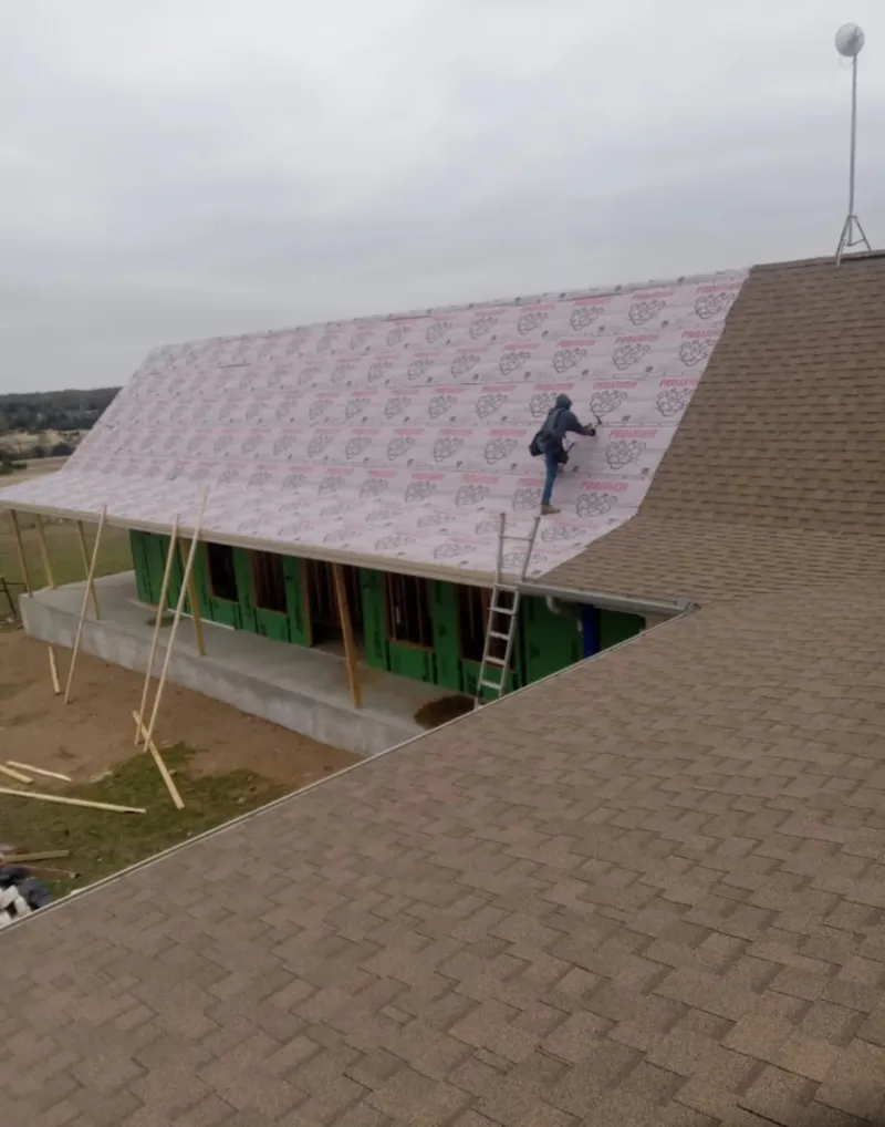 Worker preparing underlayment for a metal roof installation in Kapolei